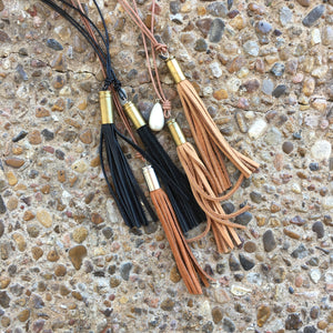 Jewelry, bullet with leather fringe on leather rope.